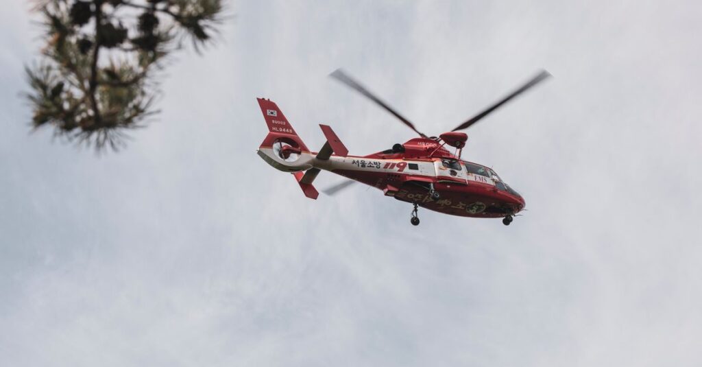 Red and white rescue helicopter flying in the sky, captured outdoors.